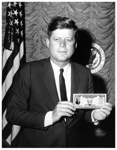 President John F. Kennedy holds a U.S. savings bond.
